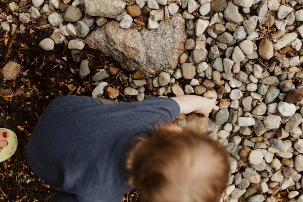Two year old milestone photoshoot, picking rocks at the river