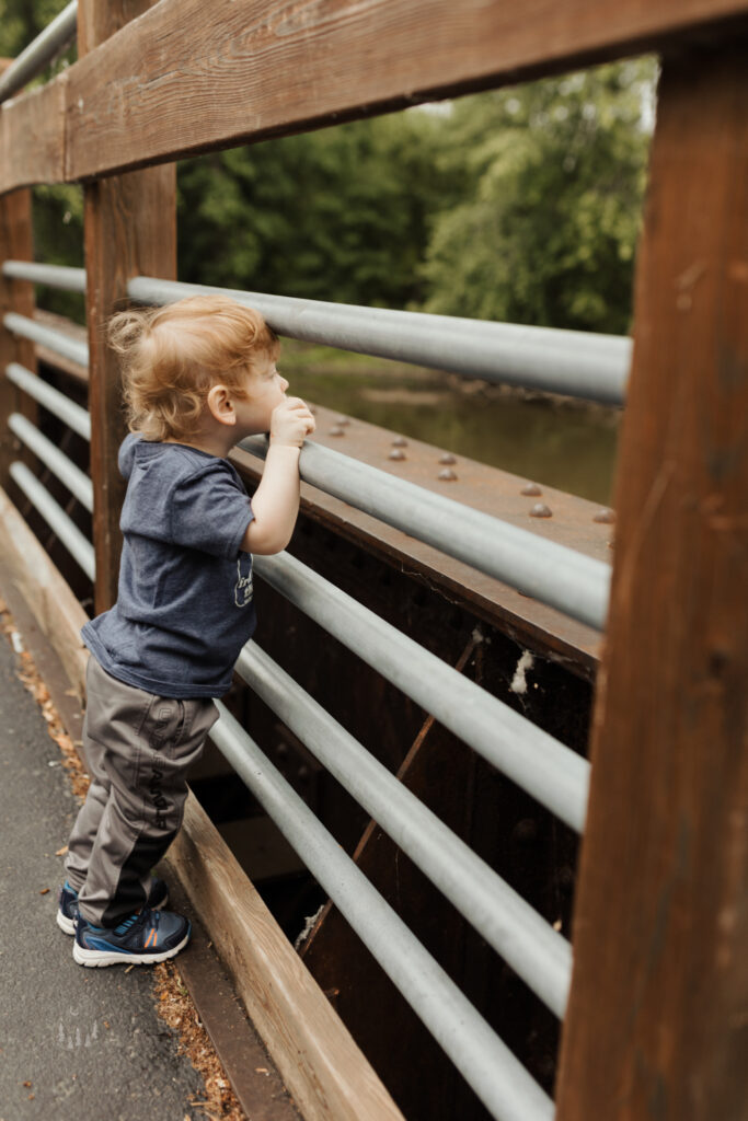 Toddler plays on the bridge during his milestone photoshoot with northern michigan photographer 