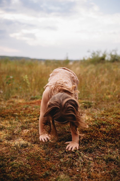 little girl feeling moss with hands
