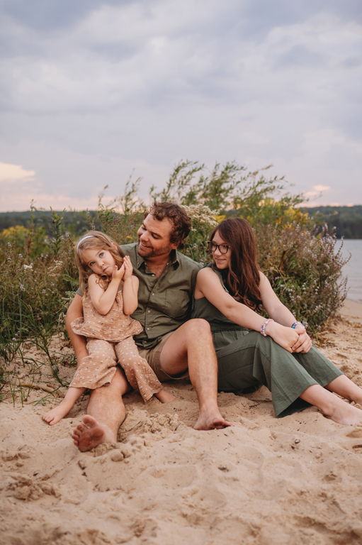 dad and daughters on the beach being silly